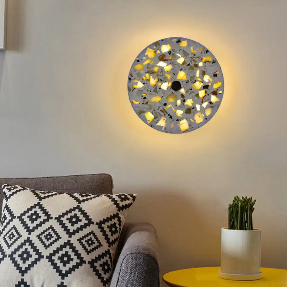 Art deco mosaic terrazzo led wall light with yellow black and gray fragments in a circular living room wall sconce