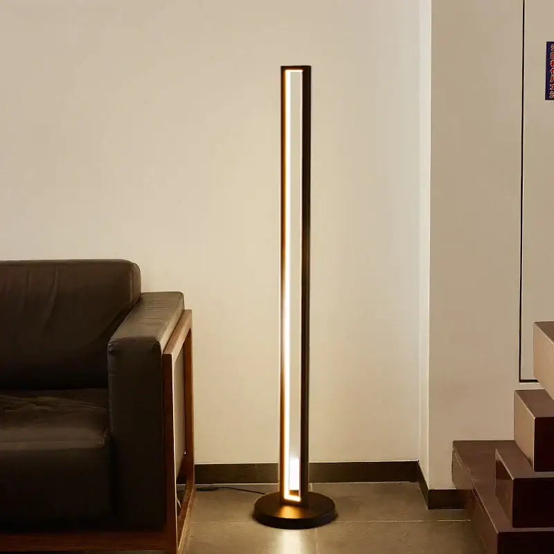 Modern minimalist art deco floor lamp with dark metallic frame and warm ambient lighting for living room decorbites art deco