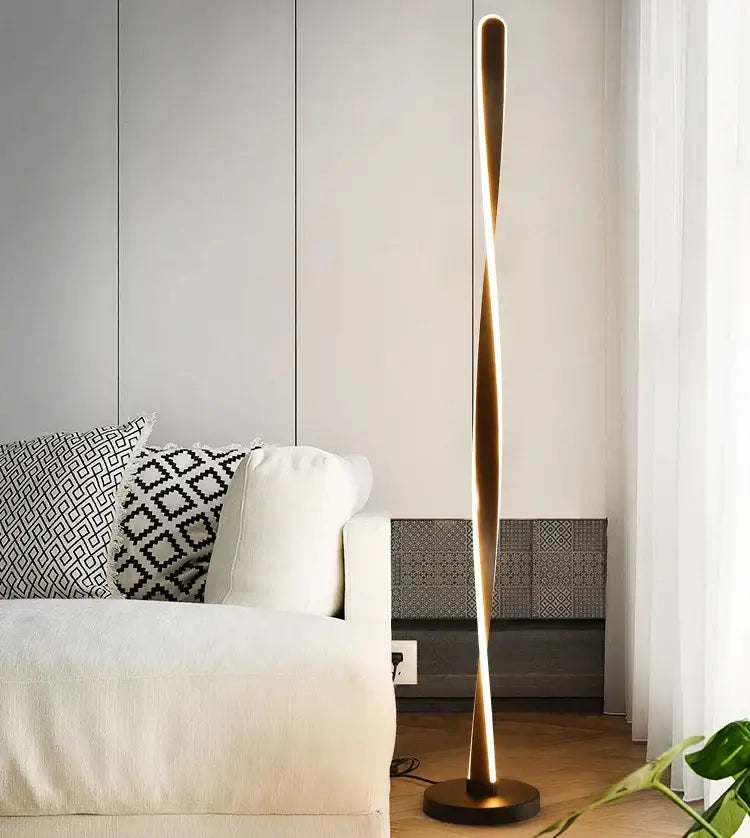 A sleek twisted gold finished floor lamp with circular base and modern design for art deco decorbites ambient lighting