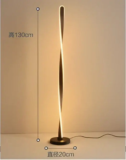 A sleek twisted gold floor lamp with art deco design providing warm ambient light by decorbites