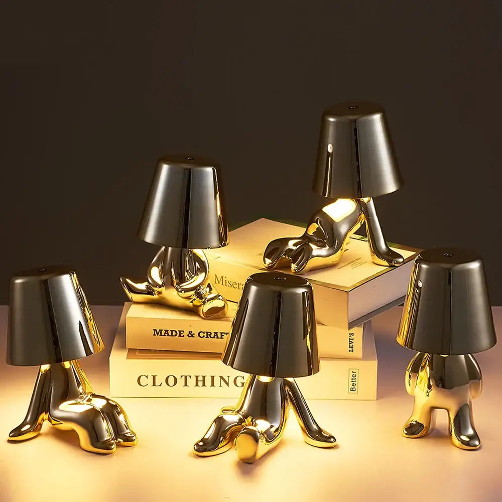 Articulated golden man table lamp with glossy finish and black lampshade head serving as a bedroom night light
