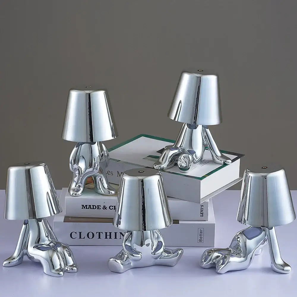 Shiny silver metallic man table lamp with lampshade head and human legs designed as a modern night light