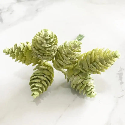A cluster of artificial green pinecones with textured layered design in decorbites green plant flower cherry bundle decor