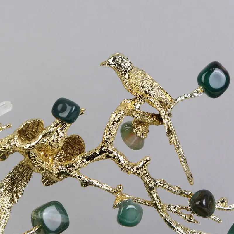 Artisan amethyst and golden tree handicraft featuring a golden bird on a textured branch with dark green gemstones