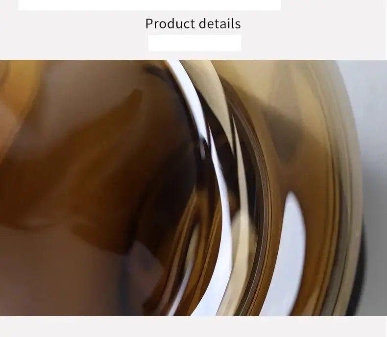 A sleek amber-colored artisan glass vase with smooth curved design and reflective surface for elegant decor