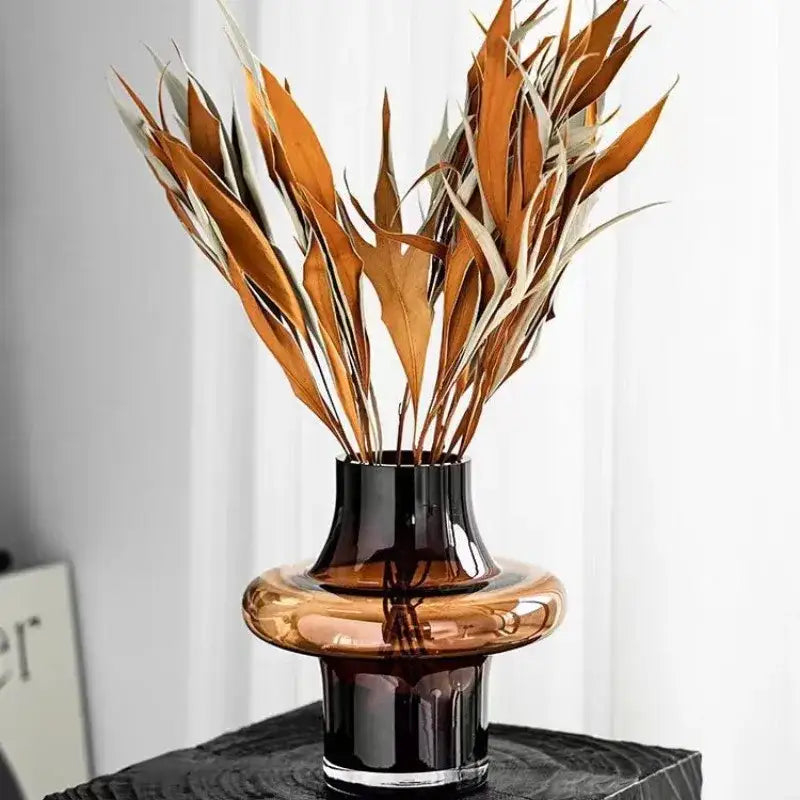 A sleek layered amber artisan glass vase with a glossy black rim and base for elegant decor