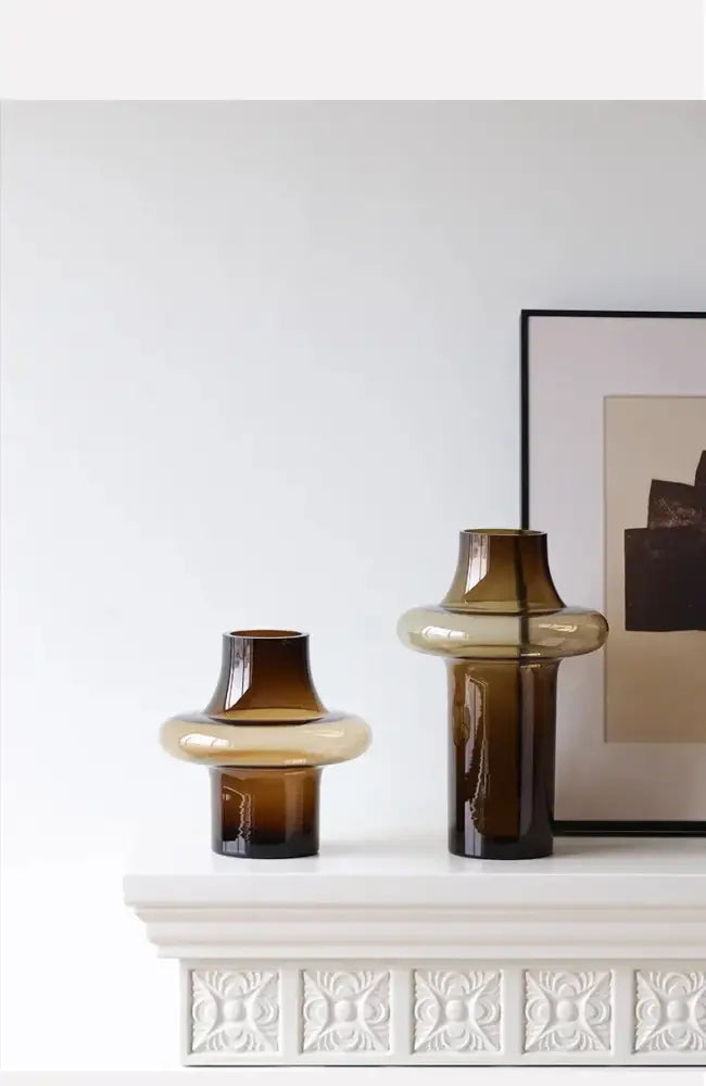Two amber-colored artisan glass vases with smooth rounded bands and tapered necks for elegant decor