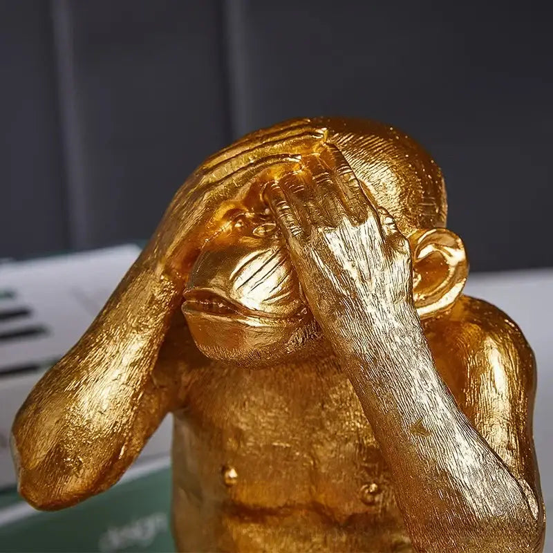 Golden metallic artisanal monkey sculpture with hands covering eyes for living room decor by decorbites golden monkey