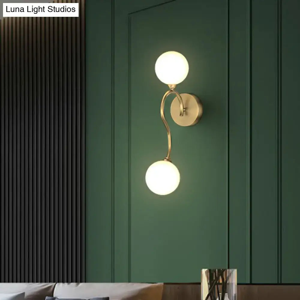 Artistic gold spherical wall lighting fixture with two frosted glass shades for elegant bedroom illumination