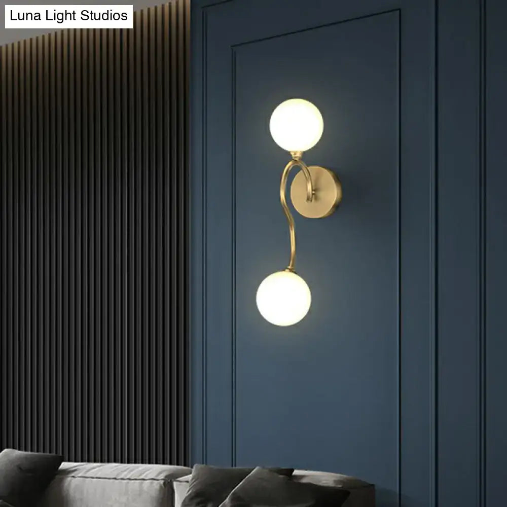 Artistic gold wall lighting fixture with two milky glass spherical shades for bedroom wall sconce lighting