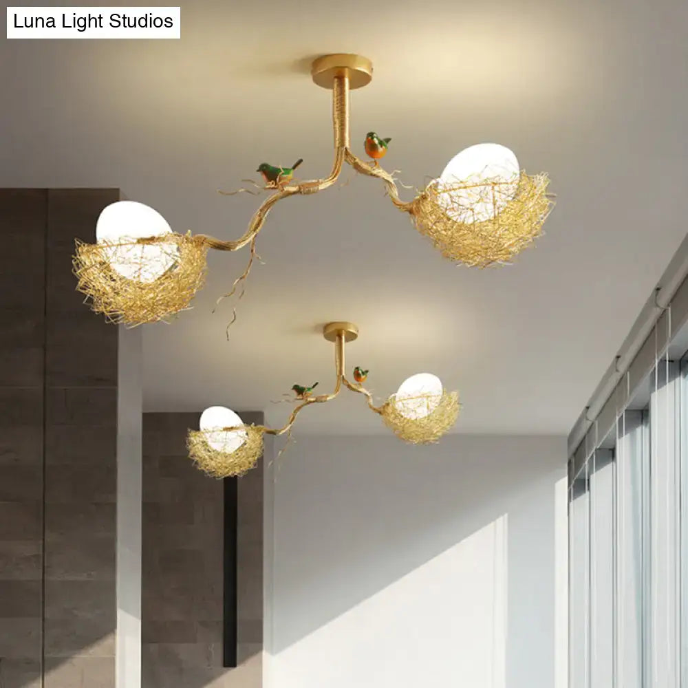 Gold-toned chandelier pendant with artistry milk white glass balls and hand sewn aluminum nests adorned with birds