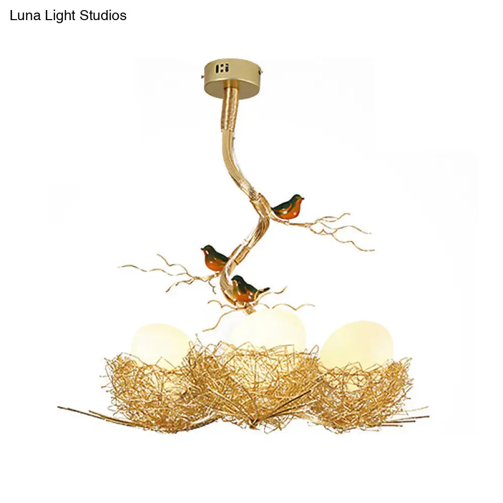 Gold-toned chandelier pendant with artistry milk white glass balls and bird-themed aluminum nest design