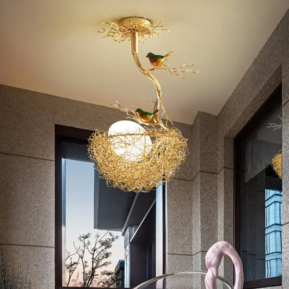 Golden chandelier pendant featuring artistry milk white glass ball with bird motif and hand sewn aluminum nest design