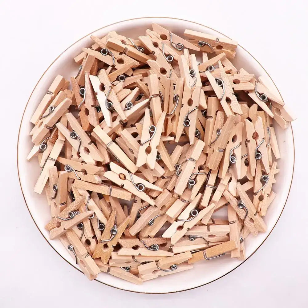A pile of light brown wooden clips with silver metal springs used as mini wooden clips for bedroom photo decor