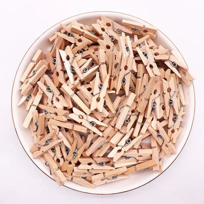 A pile of light brown wooden clips with silver metal springs used as mini wooden clips for bedroom photo decor