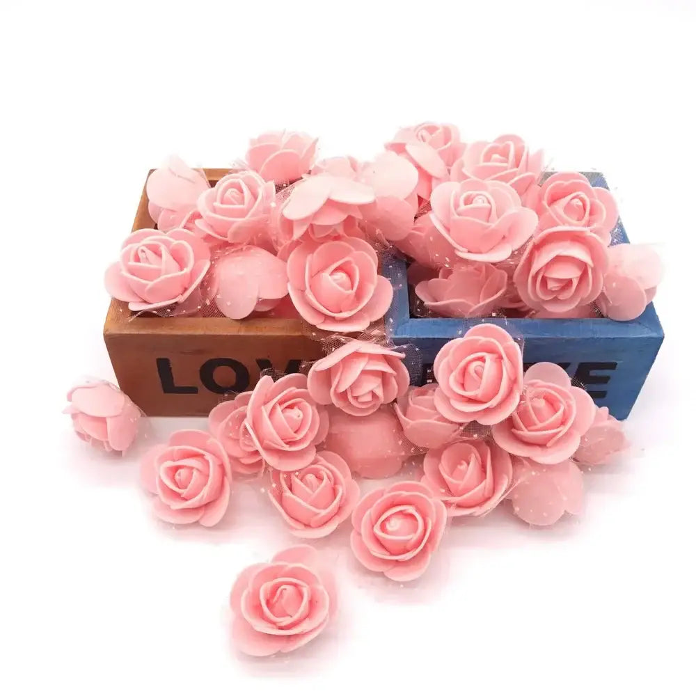 Pink handmade foam rose flower heads scattered around two wooden boxes for wedding decorbites handmade foam decor