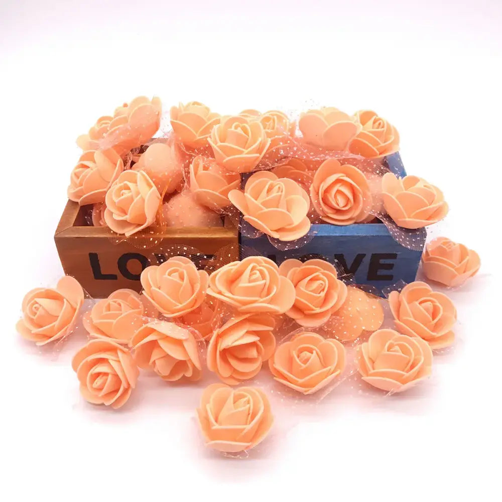 A collection of peach-colored decorbites handmade foam rose flower heads with layered petals for wedding decor
