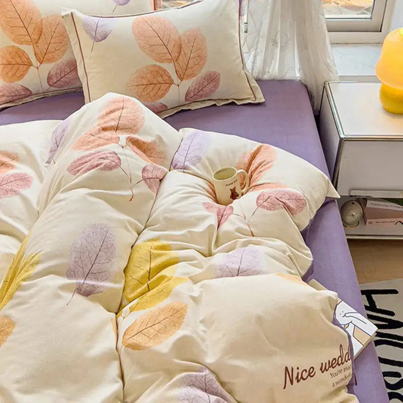 Cream-colored quilted duvet cover set in brushed cotton with soft autumnal leaf pattern in peach mauve and yellow