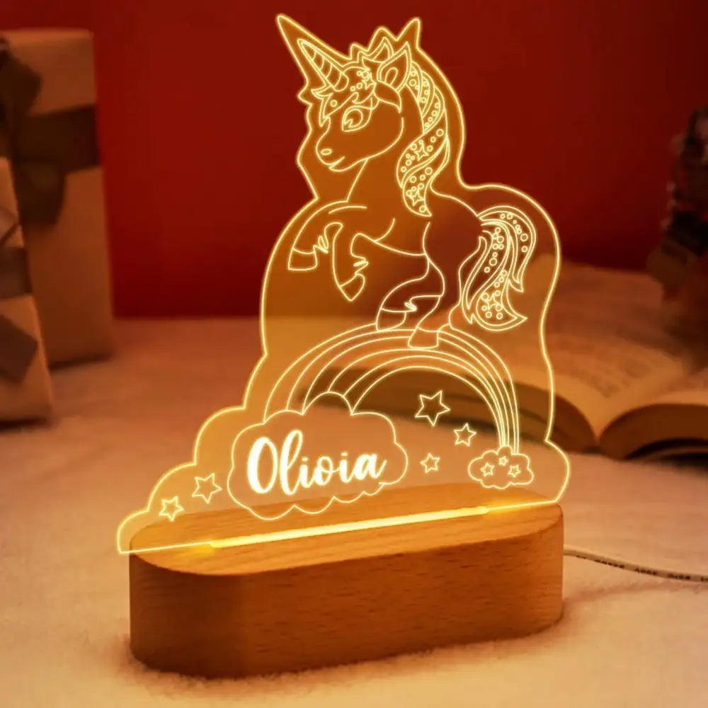A glowing translucent unicorn led night light with rainbow design personalized with the name olivia for baby kids