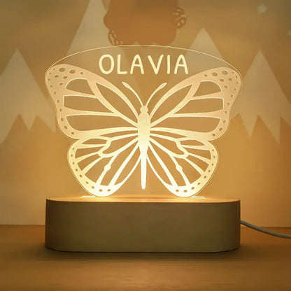 A warm glowing butterfly-shaped led night light personalized with the name olavia for baby kids nursery decor
