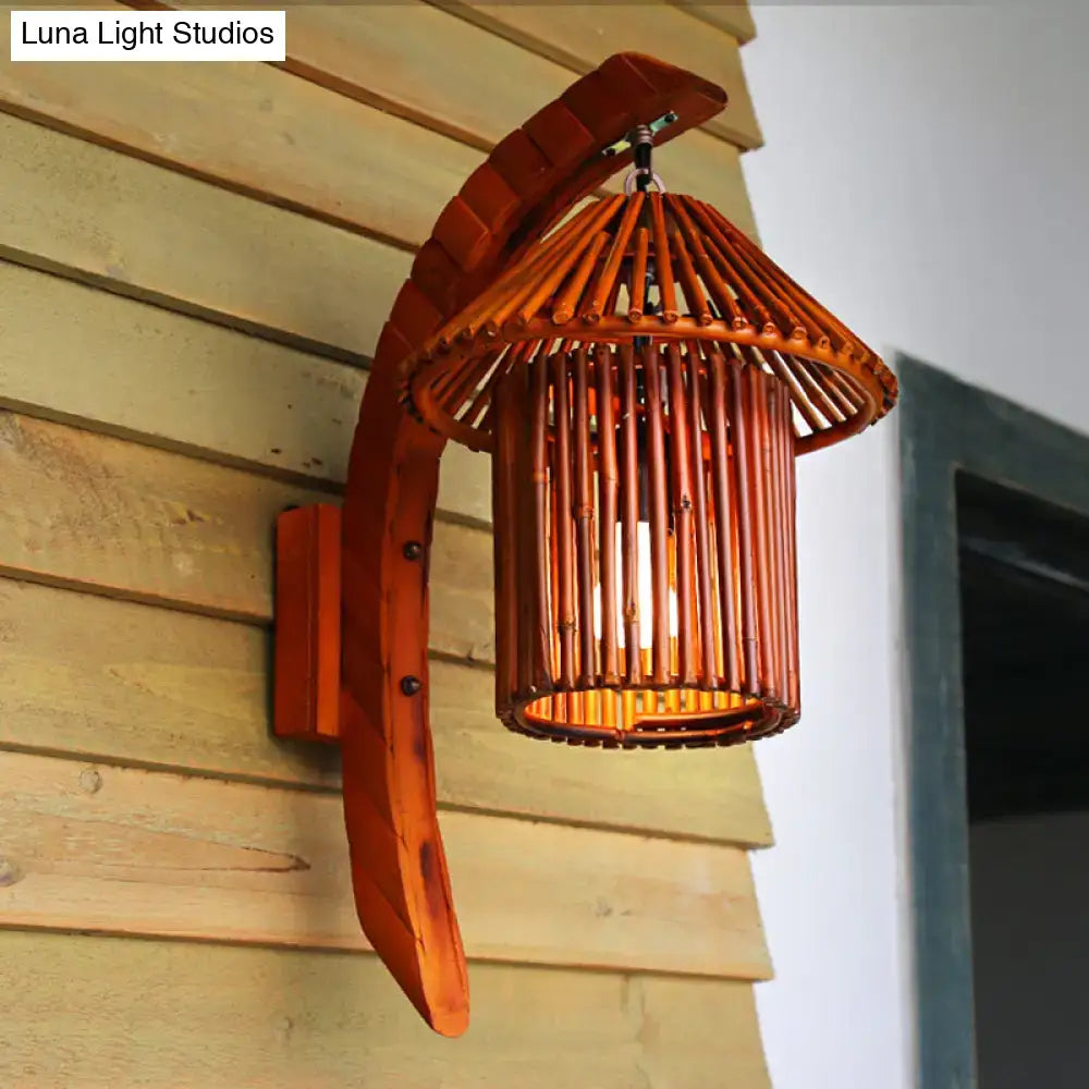 Warm-toned bamboo country house wall light fixture with curved wooden arm and woven cylindrical shade in brown