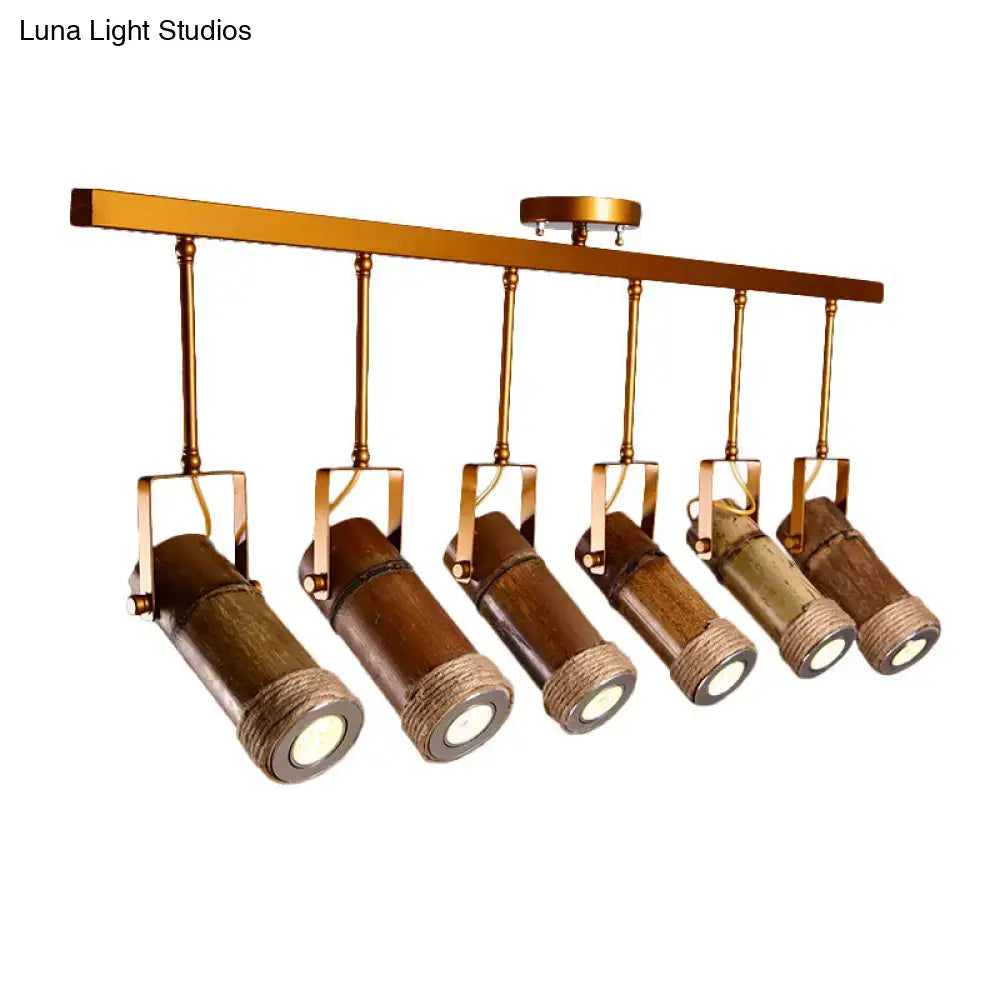 Six bamboo tube led light pendant fixtures with hemp rope and brass accents hanging from a gold-toned bar