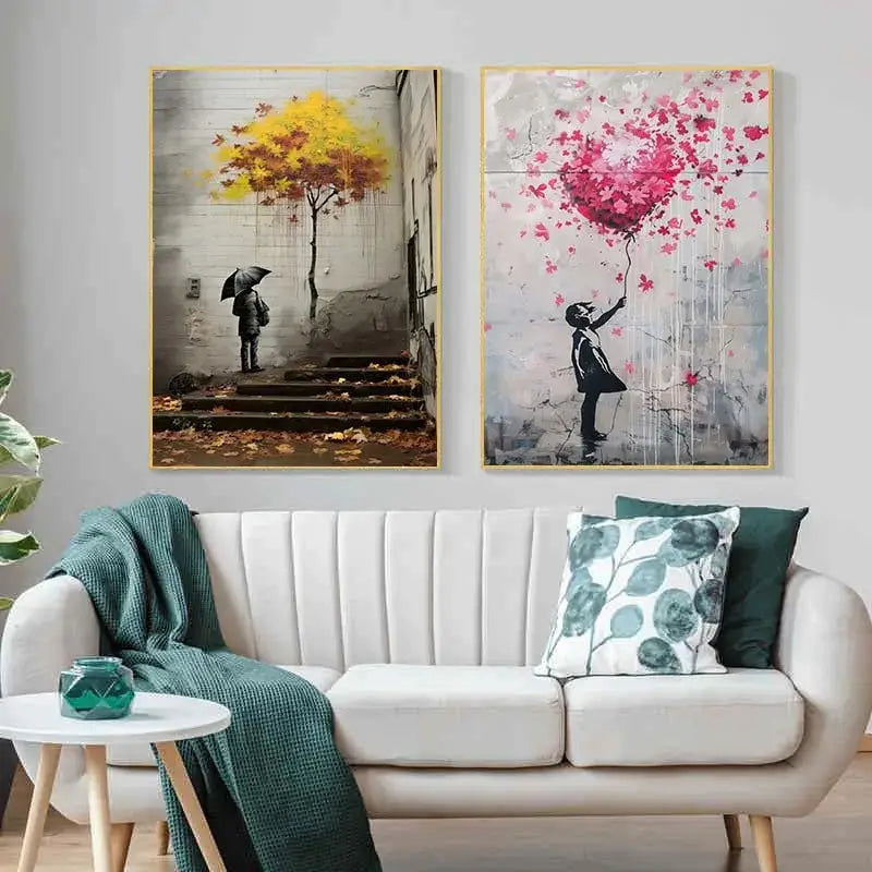 Two framed decorbites™ banksy boy girl balloon canvas prints above a white sofa featuring iconic street art designs