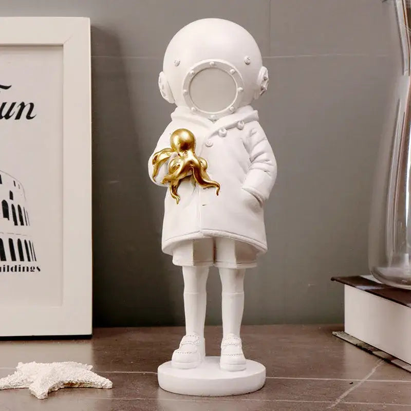 White resin banksy deep diver sculpture featuring a child in a vintage helmet holding a golden octopus for living room decor
