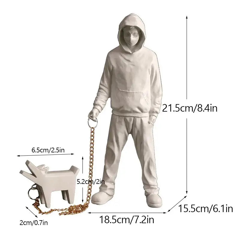 White resin banksy sculpture collection figurine of a hooded figure holding a gold chain leash with a dog keychain
