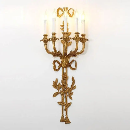 Golden ornate baroque antique brass wall sconce by decorbites with five candle lights and leafy ribbon design for dining room