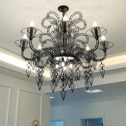 Black wrought iron baroque designer hanging chandelier with intricate swirling arms and geometric crystal pendants