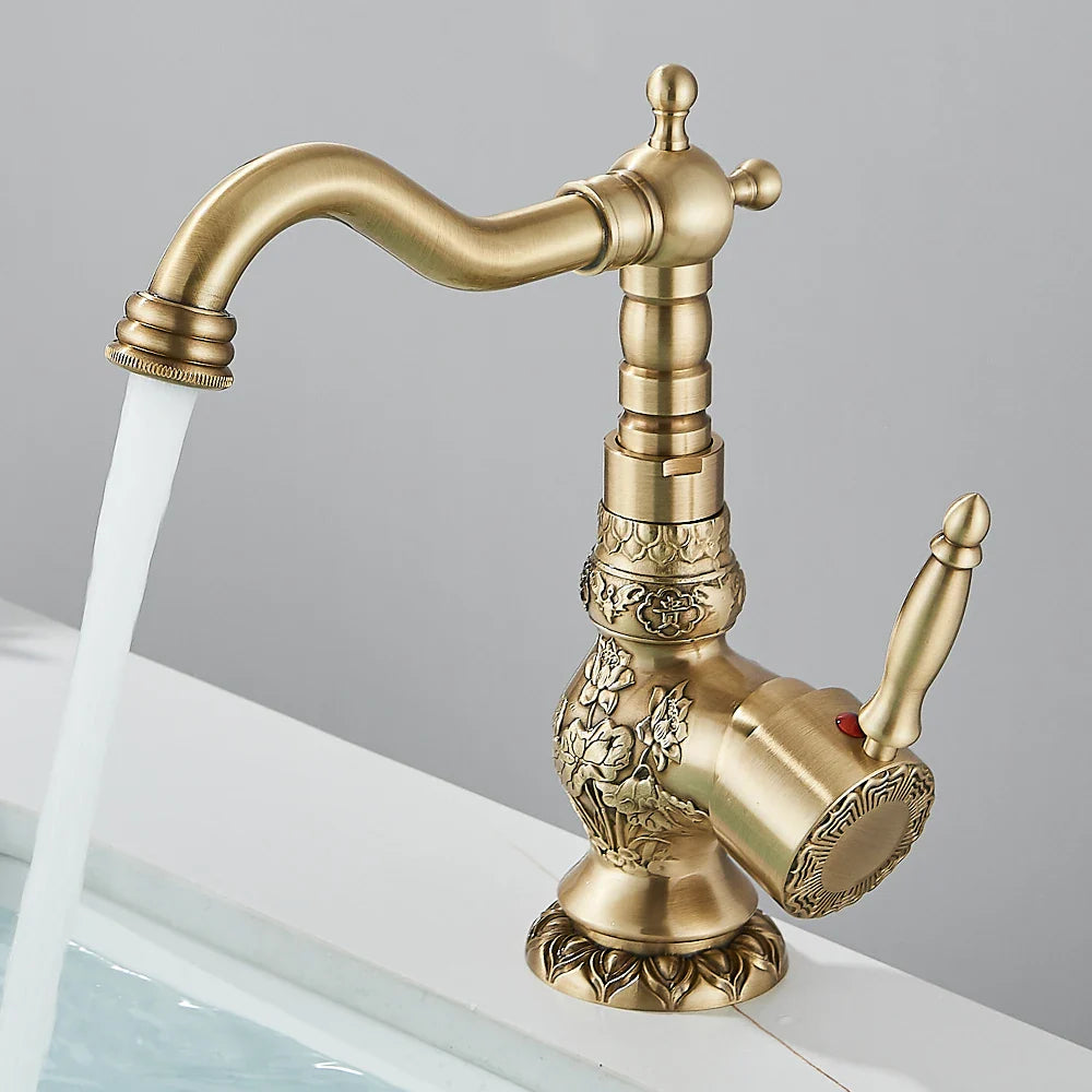 Antique brass single hole basin faucet with ornate floral engravings and curved spout for bathroom vessel sinks