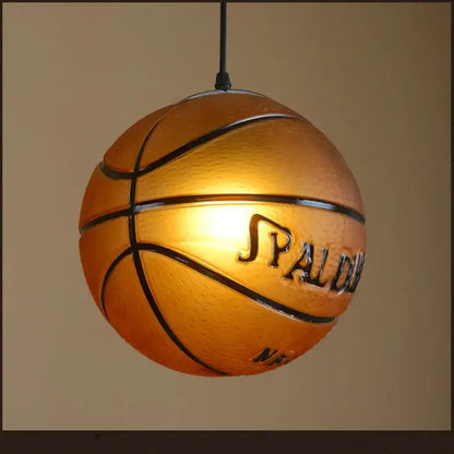 Warm glowing spalding basketball style pendant light with black seams and textured orange surface for kids bedroom decorbites