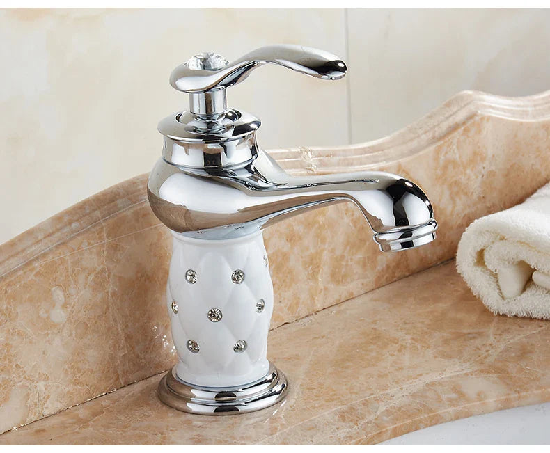 Bathroom faucet with bronze finish featuring chrome spout and white ceramic base with embedded rhinestones