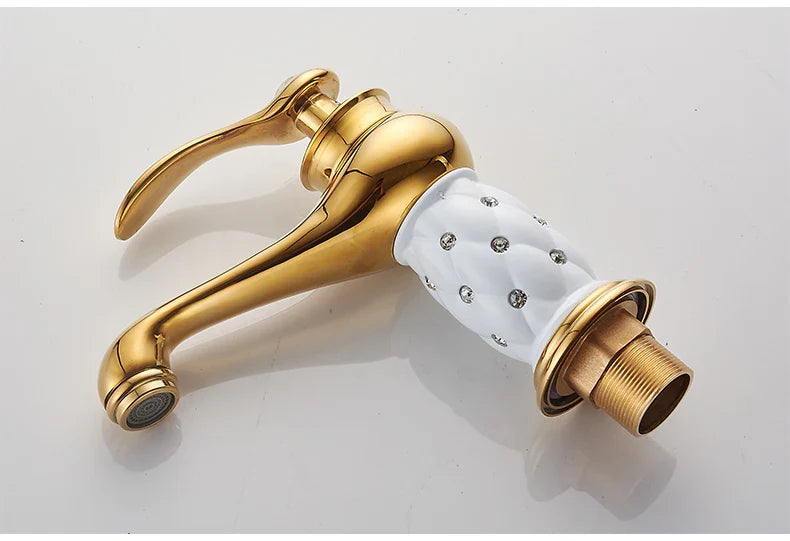 Gold-finished bathroom faucet with bronze finish and white ceramic handle featuring embedded silver rhinestones