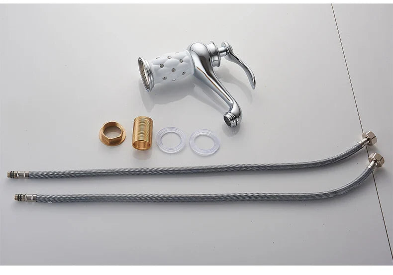 Chrome-finished kitchen faucet with white perforated spray head and flexible metal hoses in bronze finish detail