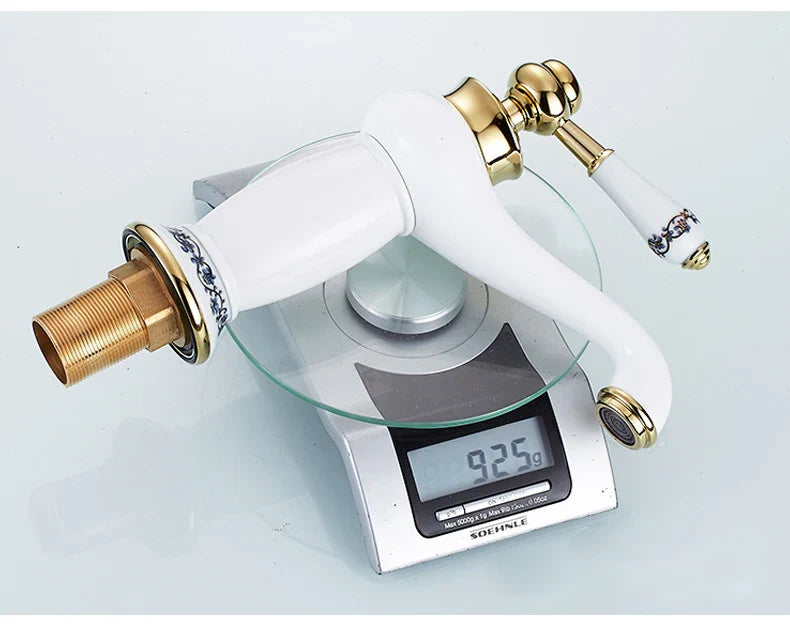 White ceramic bathroom faucet with bronze finish, gold accents, and black floral patterns featuring a brass base
