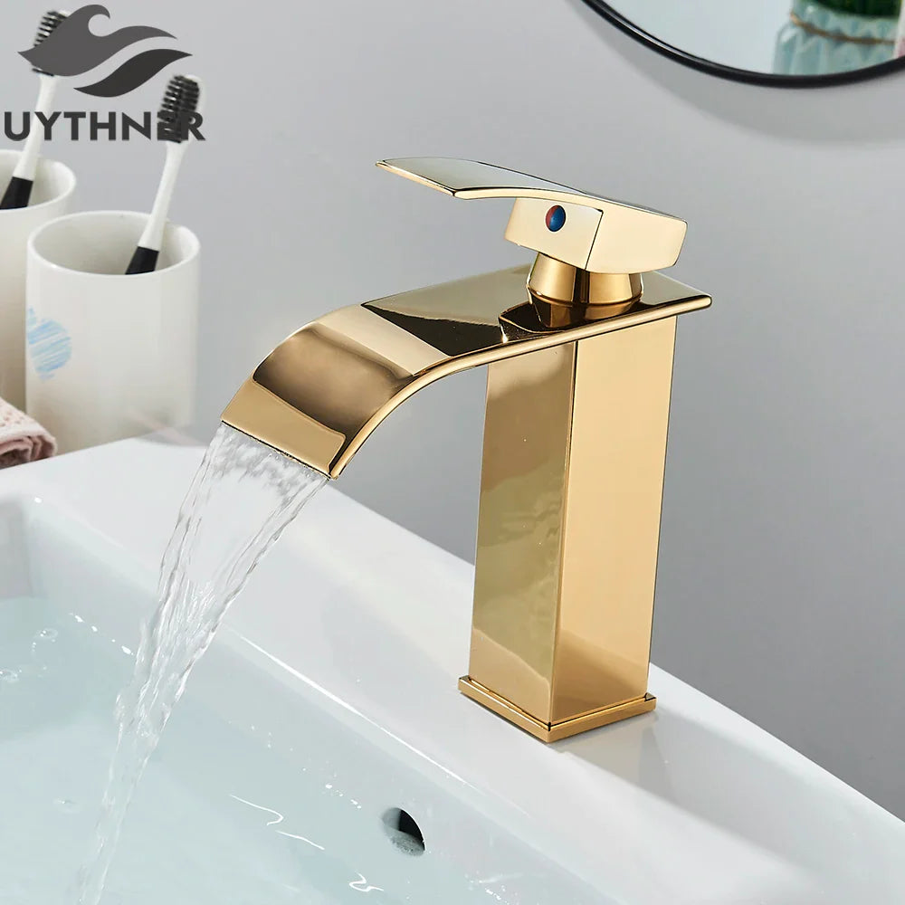 Gold-colored bathroom sink faucet brass deck mount with modern waterfall design and blue accent handle stainless steel material