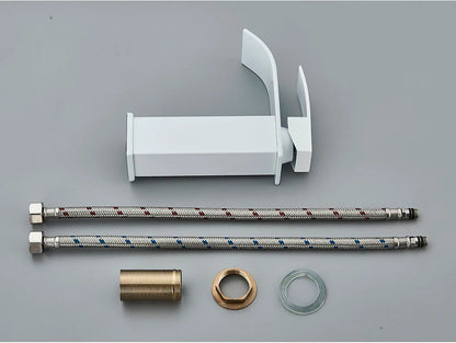 White plastic bathroom sink faucet with brass deck mount, stainless steel braided hoses, and brass fittings visible from back side