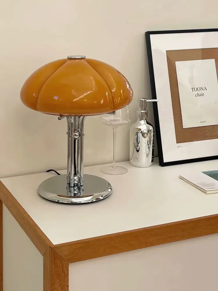A bauhaus medieval table lamp with sleek amber glass and polished chrome base for bedroom atmosphere