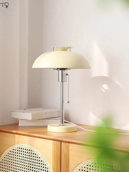 Cream-colored bauhaus led table lamp with sleek chrome stem and base for minimalist bedroom lighting