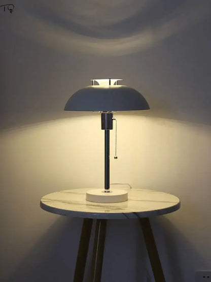 A bauhaus led table lamp with a matte gray dome shade and chrome stem, designed for bedroom use