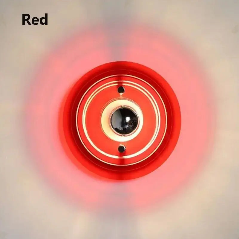 Red circular bauhaus led wall light with concentric rings and central black sphere for living room sconce