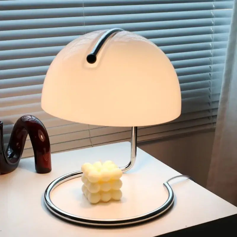 A bauhaus mushroom modern led desk lamp with a white translucent acrylic shade and polished chrome base for bedroom use