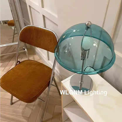 A bauhaus mushroom table lamp with a translucent teal glass dome and polished chrome base for bedroom night light