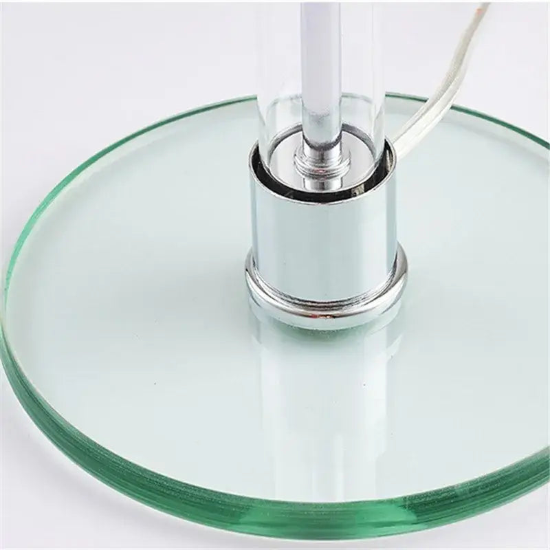 A bauhaus mushroom table lamp with a sleek clear glass base and chrome metal finish for bedroom lighting