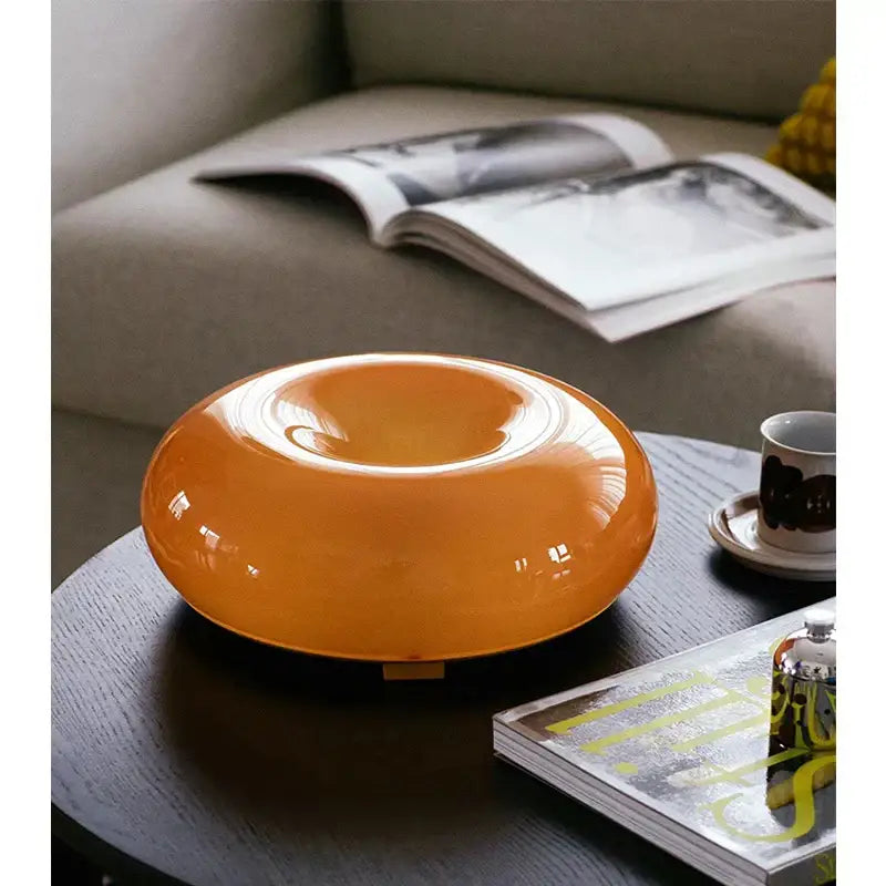 Glossy bauhaus orange glass translucent donut-shaped table lamp with smooth rounded design for bedroom accessory