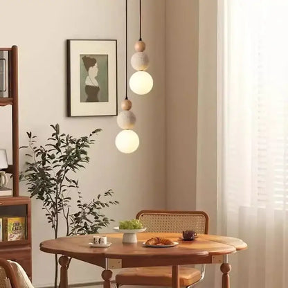 A modern bauhaus pendant light with travertine stone and wood spheres in matte white works beautifully in dining rooms