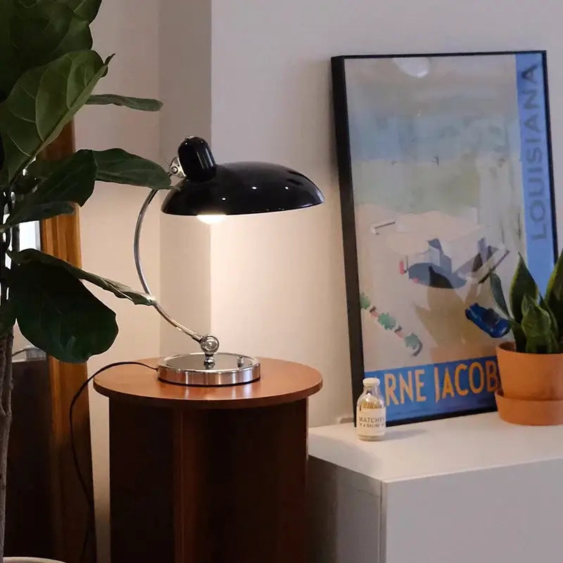 Black metal desk lamp with sleek curved arm and polished chrome base for bauhaus vintage desk office or bedroom use