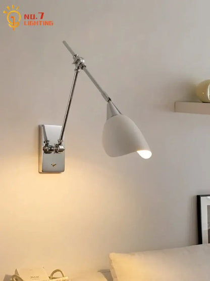 A bauhaus vintage swing arm wall lamp with chrome metal arm and base and white ceramic shade for living room use